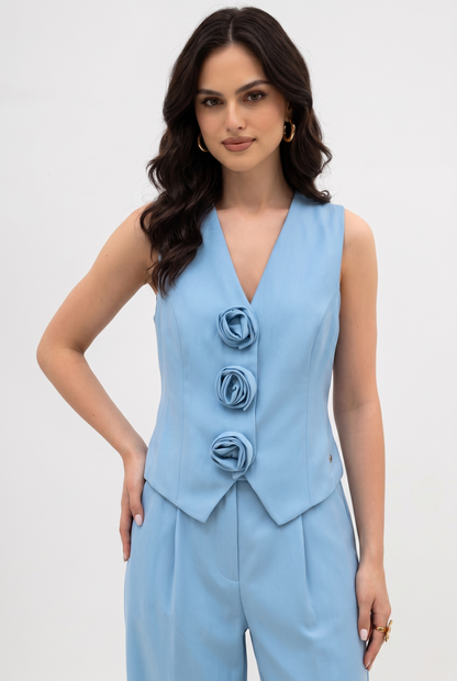Woman wearing light-blue sleeveless rose-trim waistcoat with V-neckline